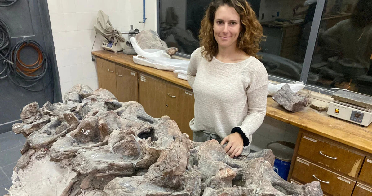Alexandra Reutter junto a las vértebras del dinosaurio gigante hallado en la Patagonia