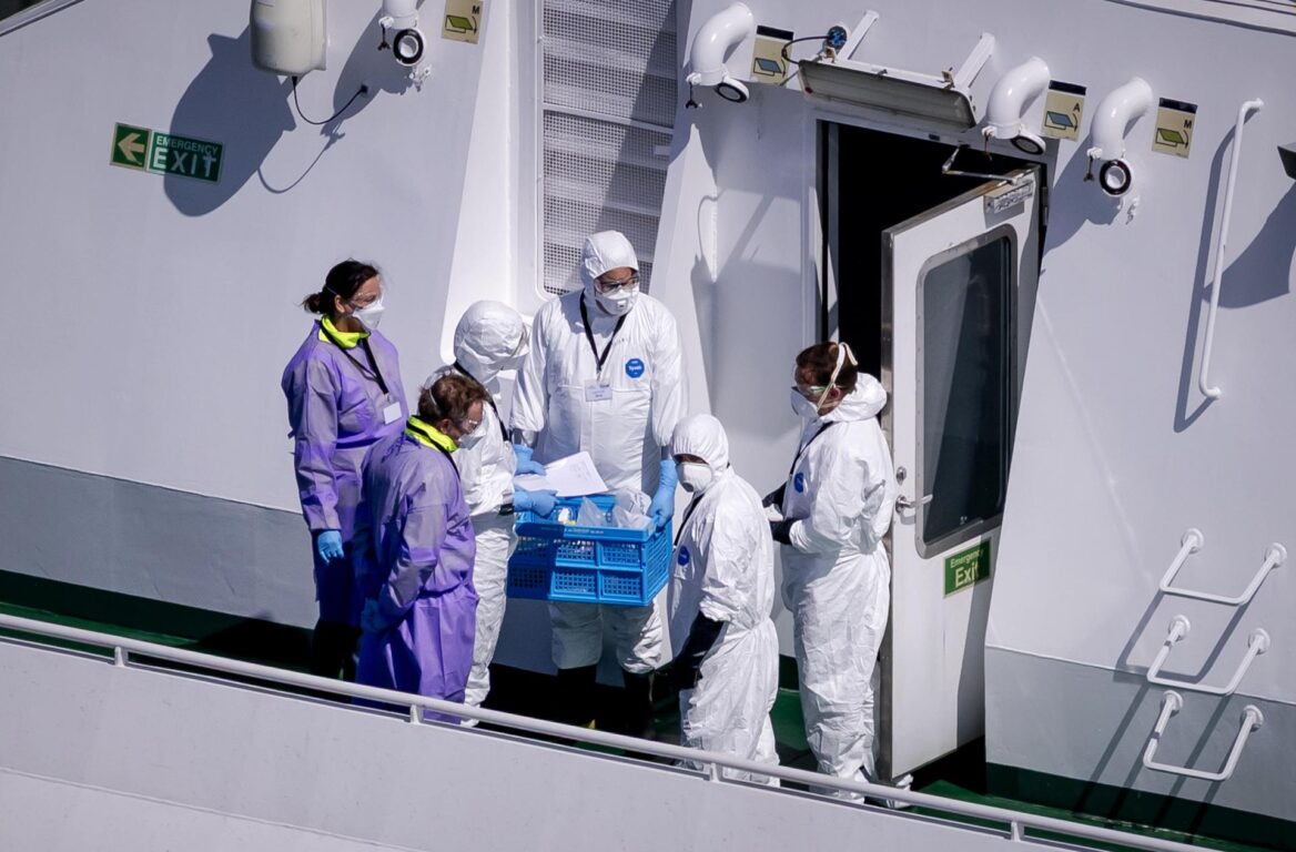 Personal del Erasmus MC, vestido con trajes blancos, sube a bordo del crucero MV Hondius 