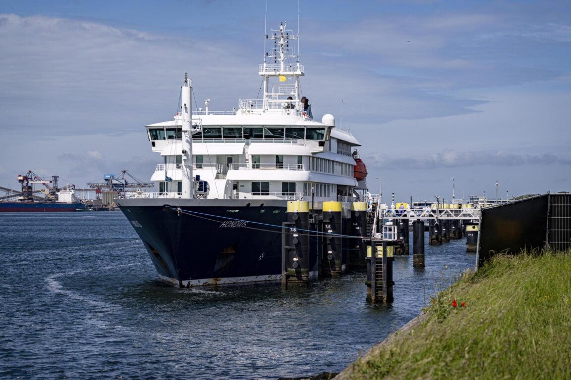Personal del Erasmus MC, vestido con trajes blancos, sube a bordo del crucero MV Hondius 