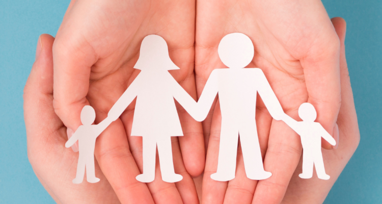 Manos con figuras recortadas que representan una familia