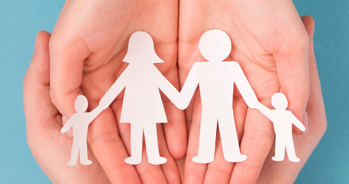 Manos con figuras recortadas que representan una familia