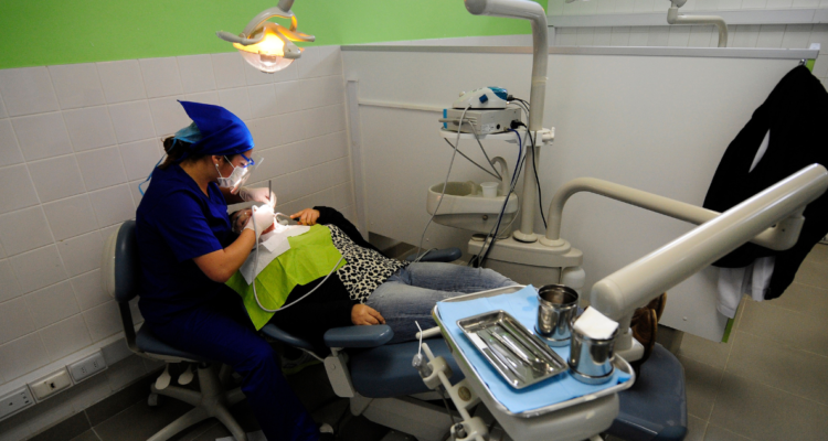 Dentista brindando atención odontológica a paciente.