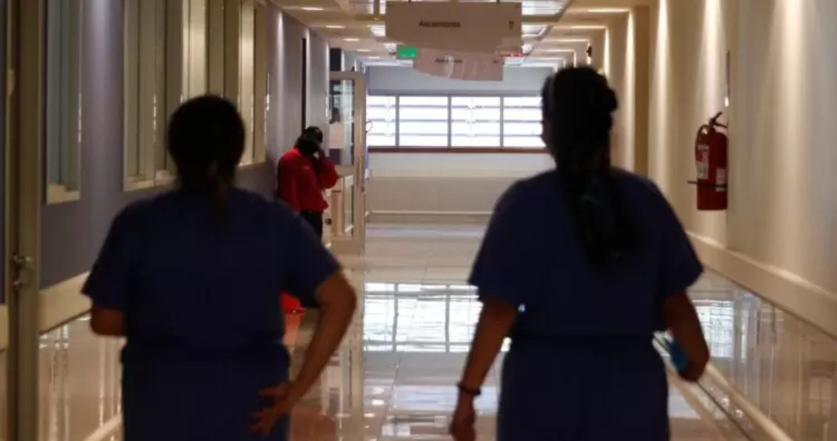 Personal de salud caminando por un pasillo de hospital