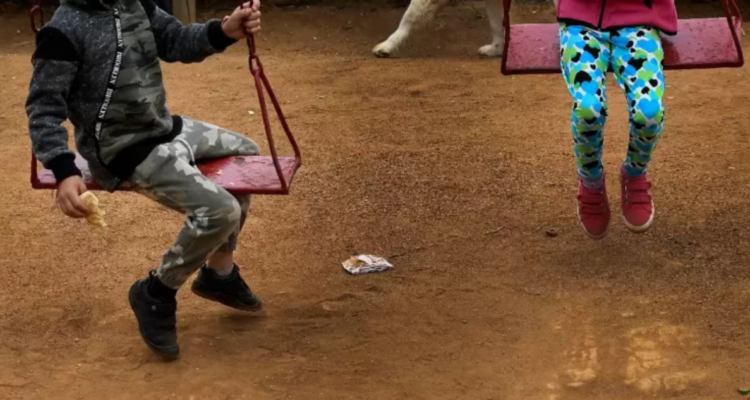Niños en un patio usando columpios