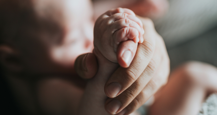 Mano de mamá y de recién nacido
