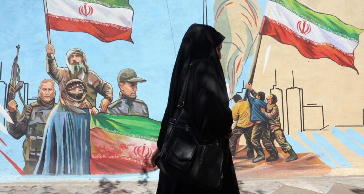 Una mujer pasa junto a un mural en una calle de Teherán, Irán, el 8 de junio de 2026