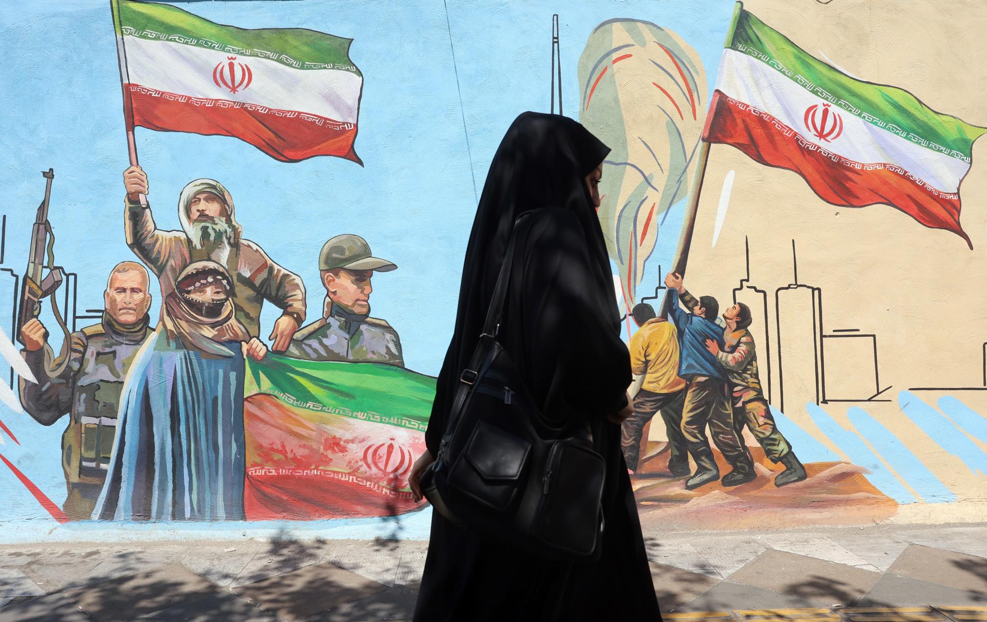 Una mujer pasa junto a un mural en una calle de Teherán, Irán, el 8 de junio de 2026