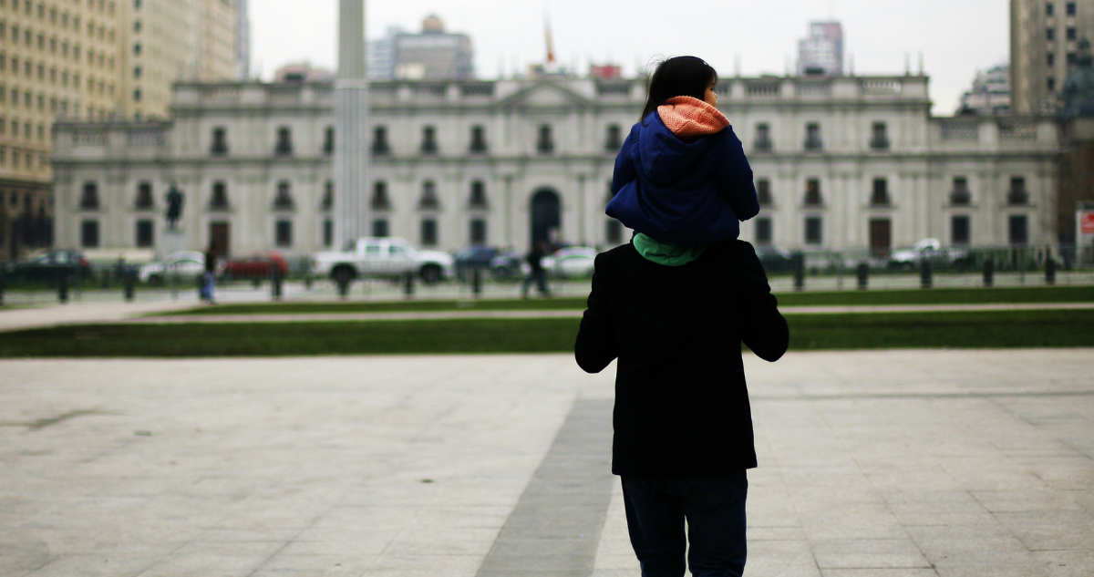 Un padre con su hijo mirando La Moneda.