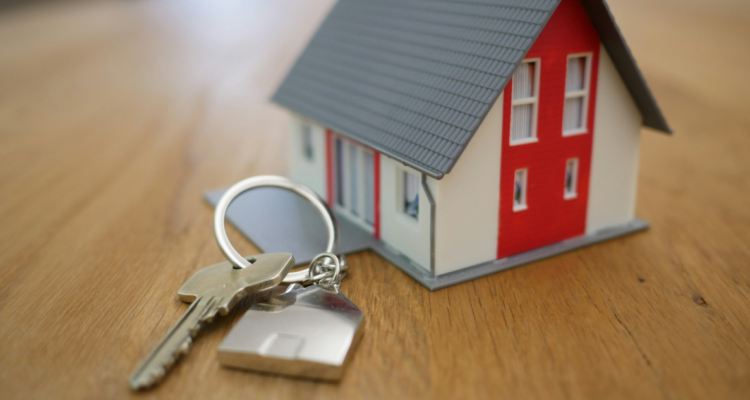 Llaves junto a una casa en miniatura para contextualizar subsidio de vivienda.