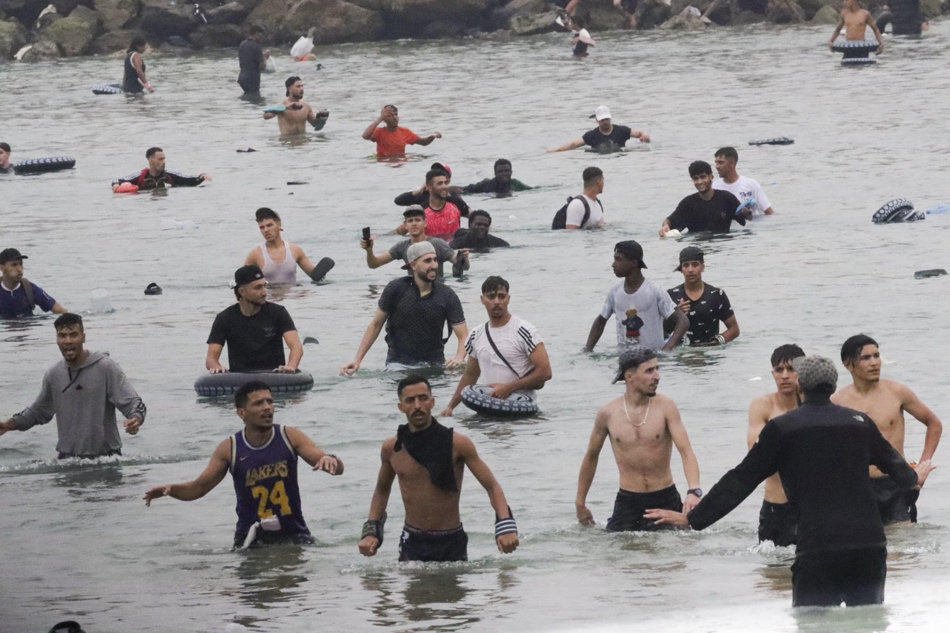 Un grupo de inmigrantes en la playa junto al paso fronterizo del Tarajal en Ceuta este viernes