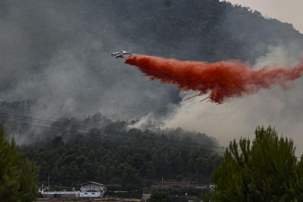 Un avión realiza una descarga con retardante en Betxí en el frente del incendio declarado el sábado en la Vall d'Uixó (Castellón) 