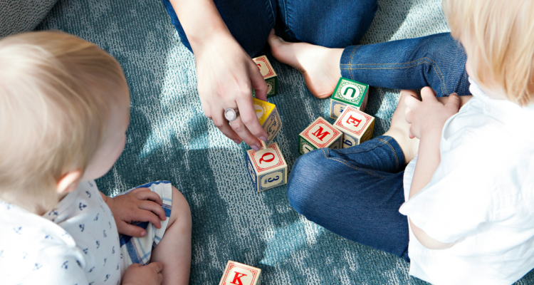 Adulto jugando con niños de diferentes edades.