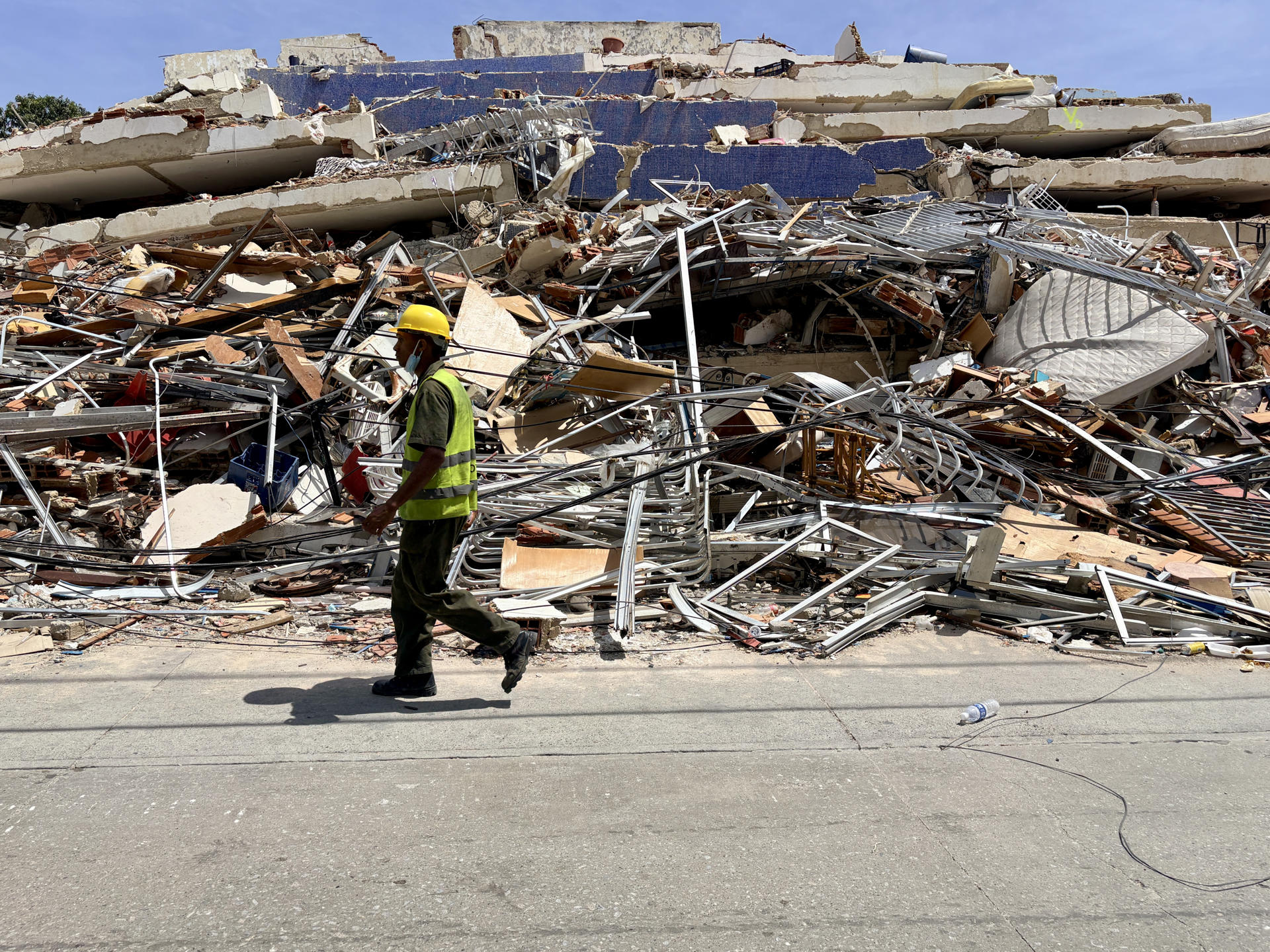 Un hombre camina frente a escombros de una edificación derrumbada por terremotos en La Guaira, Venezuela