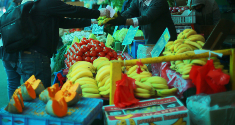 Persona comprando verduras y frutas.