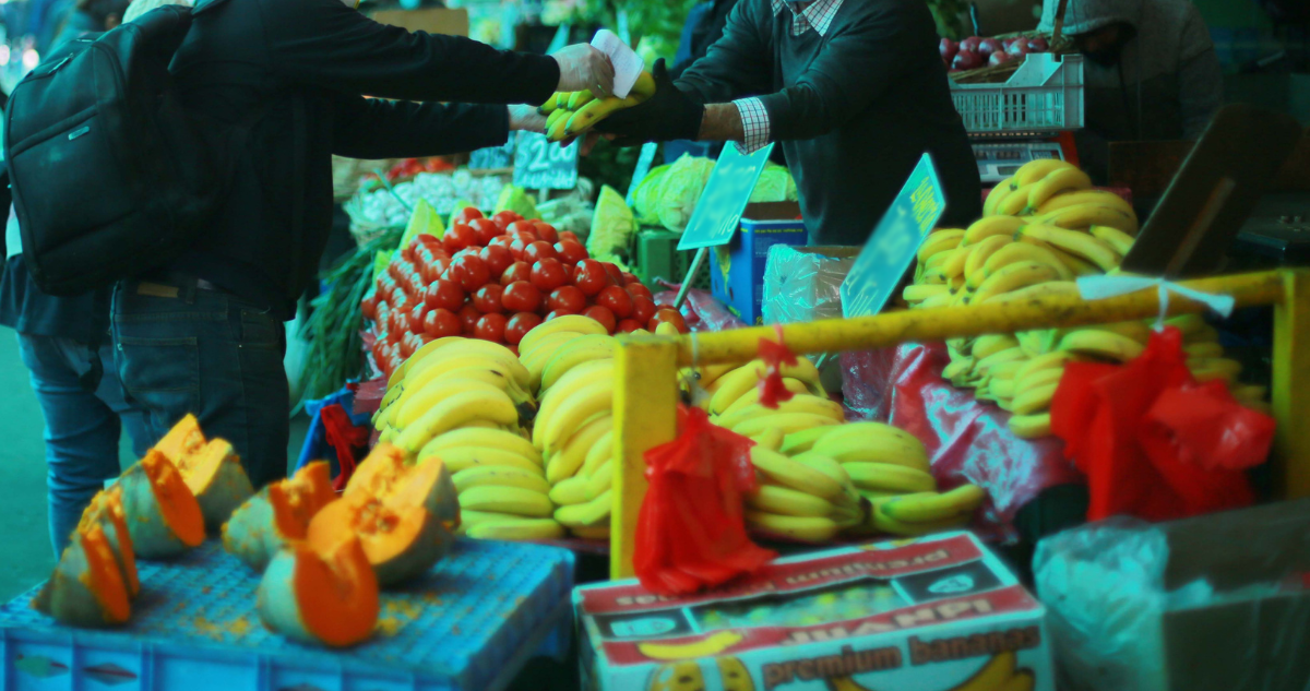 Persona comprando verduras y frutas.