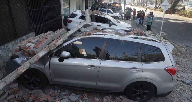 Un vehículo afectado por un muro tras el terremoto de este lunes en Cali