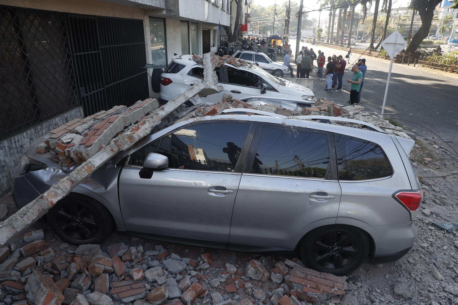Un vehículo afectado por un muro tras el terremoto de este lunes en Cali