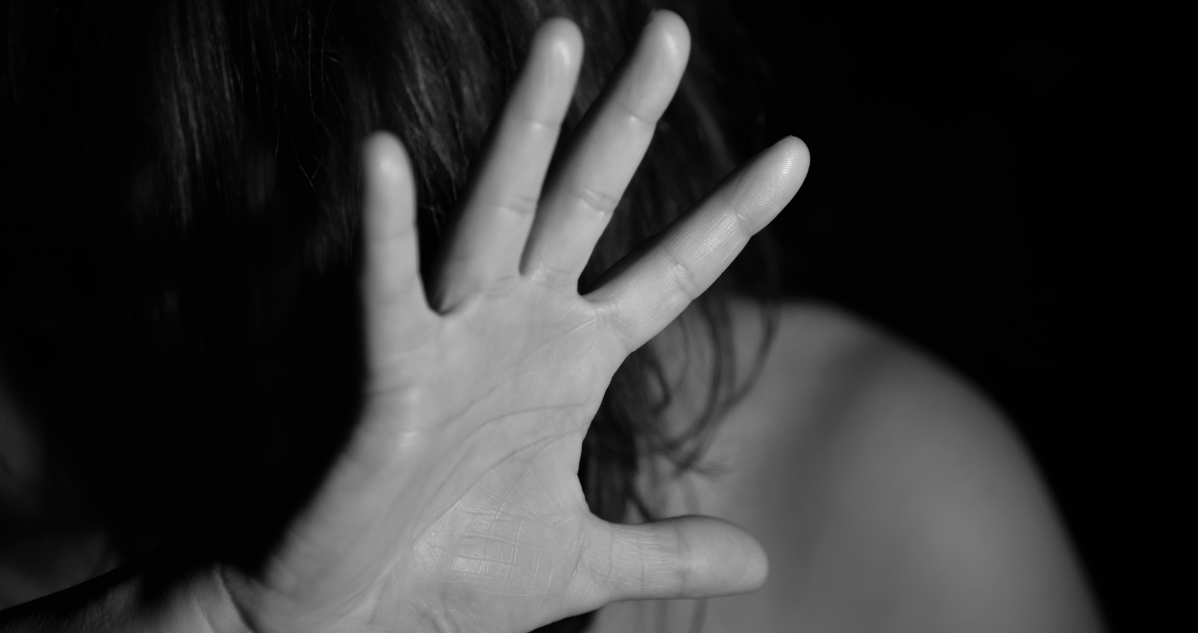 Foto de contexto de mujer protegiendo su rostro con una mano.