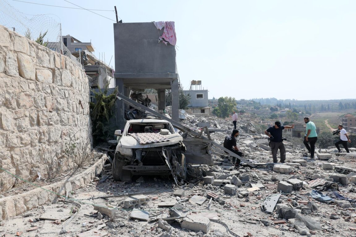 Personas inspeccionan un edificio dañado tras un ataque aéreo israelí en la localidad de Ansar, en el sur del Líbano, el 15 de agosto de 2026