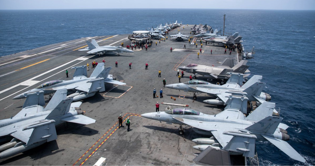 Marineros trabajan en la pista de aterrizaje del USS George Washington mientras cruza el mar Arábigo