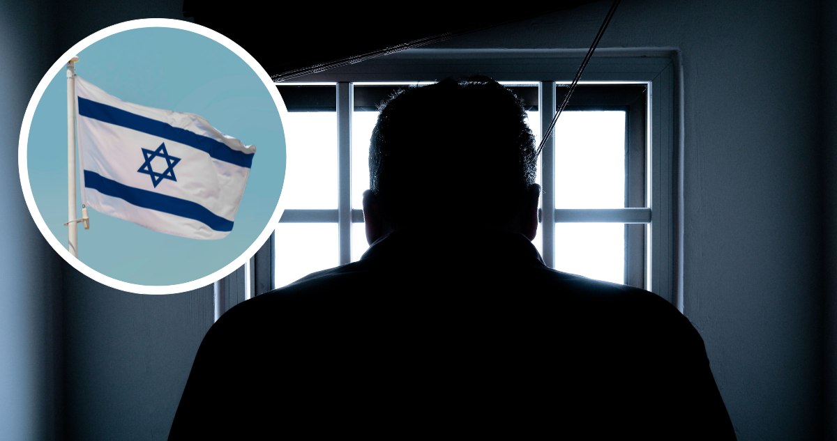 Persona en sombras encerrada, mirando por una ventana. Foto de bandera de Israel.