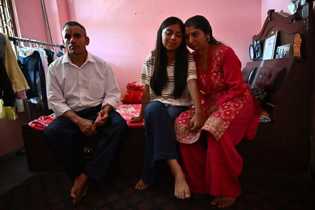 Santoshi Dotel y sus padres | Pedro PARDO (AFP)