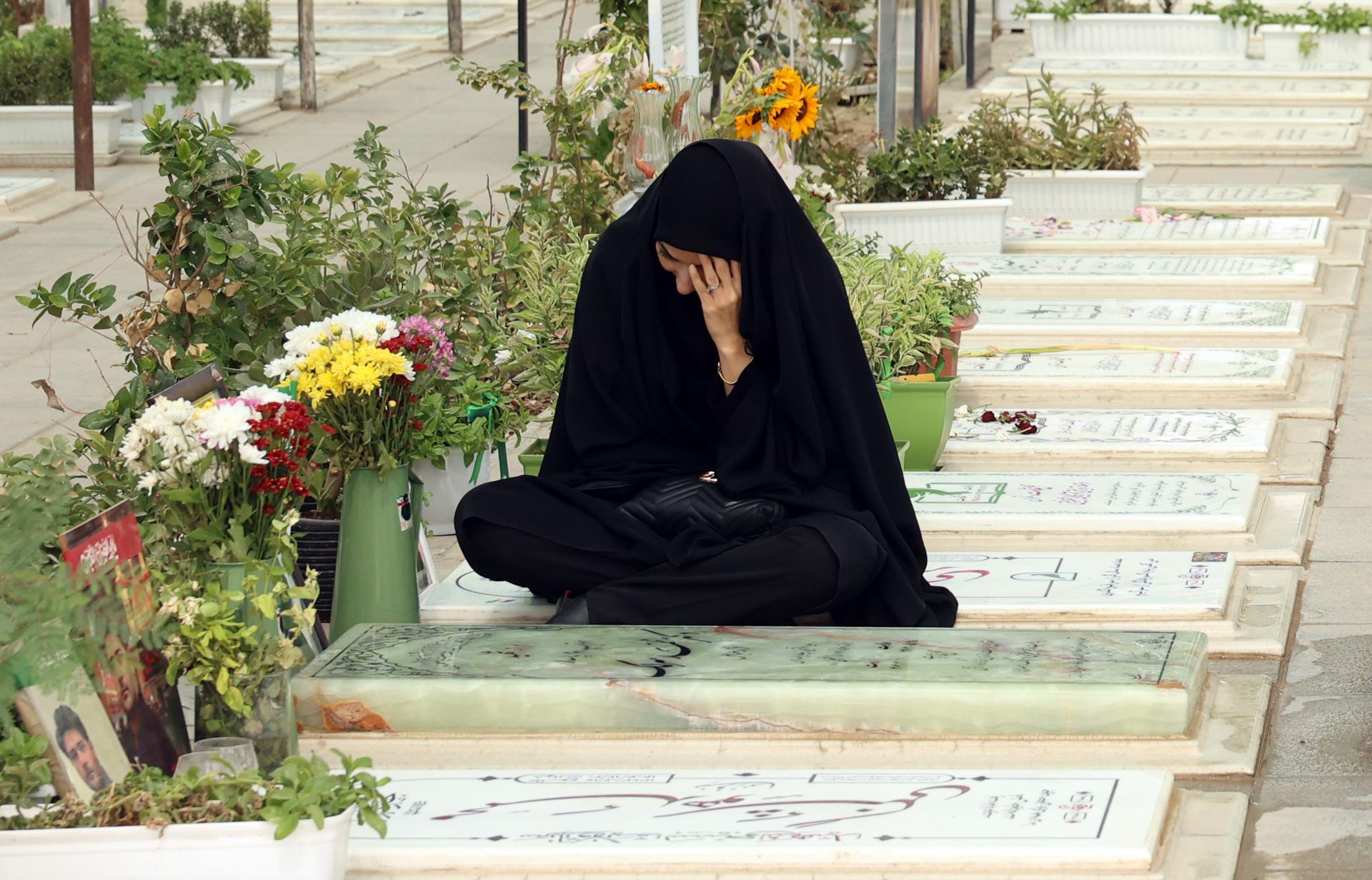 Una mujer iraní visita a sus familiares muertos en el cementerio de Behesht-e Zahra, en el sur de Teherán
