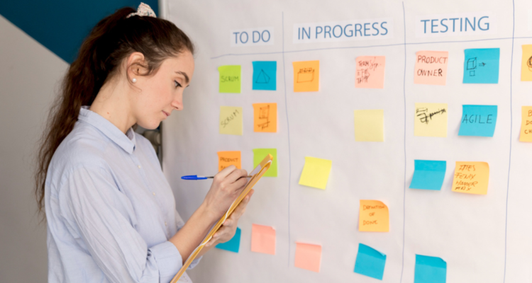 Mujer usando un tablero Kanban como método para hacer actividades con TDAH o déficit atencional