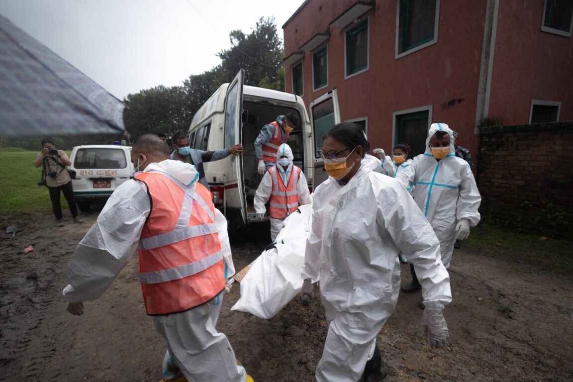 Militares y policías trasladan los cuerpos de víctimas no identificadas a una fosa común en Dakshin Dhoka, Nepal 