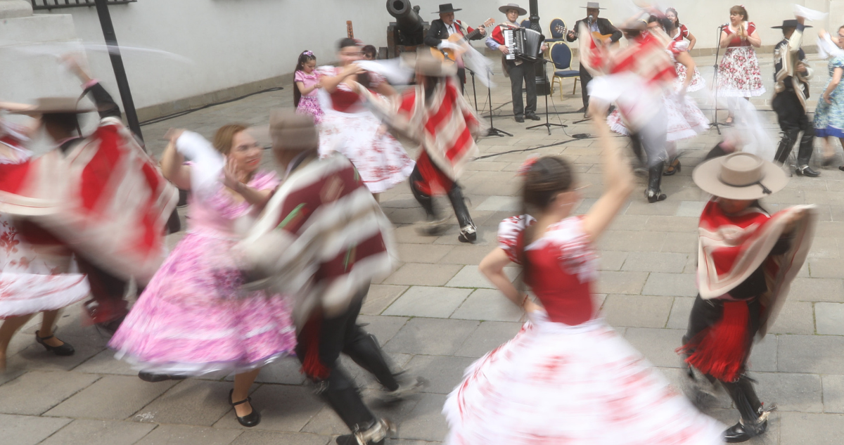 Personas bailando cueca en Fiestas Patrias.