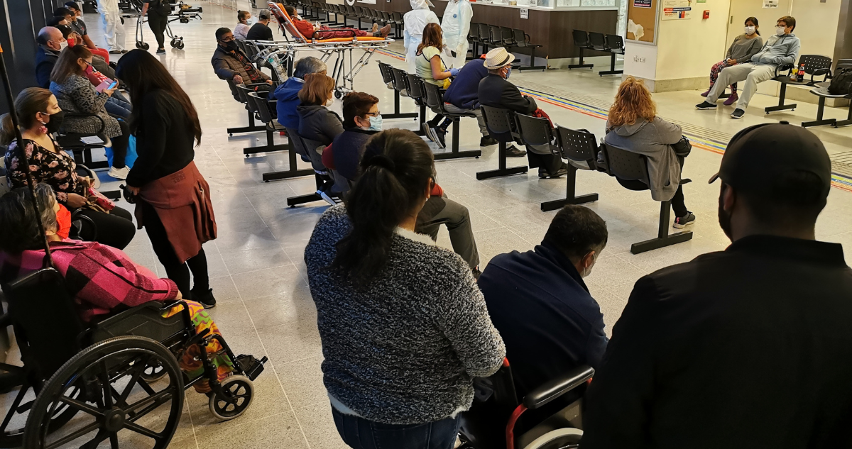 Personas en sala de espera de recinto de salud.