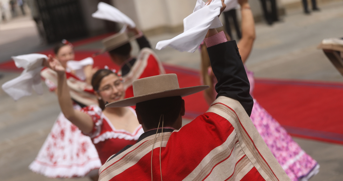 Personas con traje típico bailando cueca.