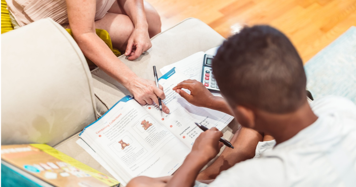 Niño haciendo las tareas junto a su madre.