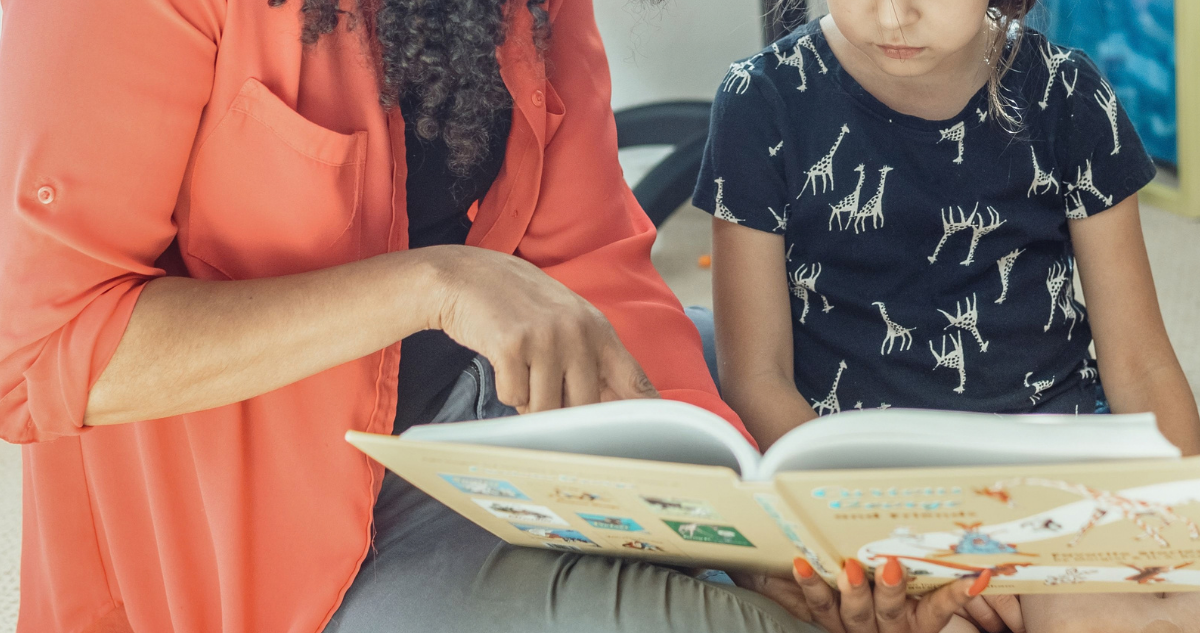 Madre e hija leyendo un libro.